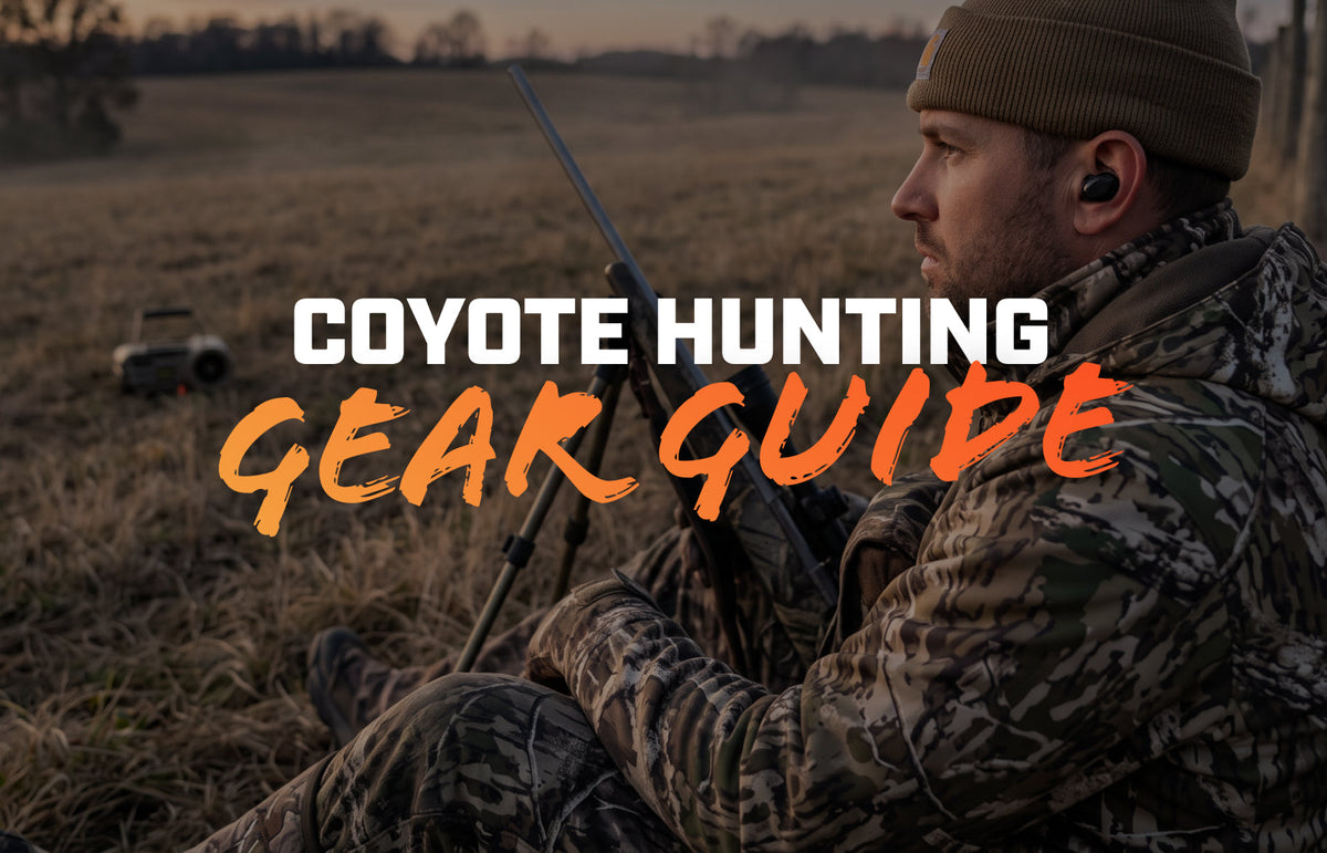 Hunter in camo against a fence post at dusk with rifle on shooting sticks and an electronic caller in the field
